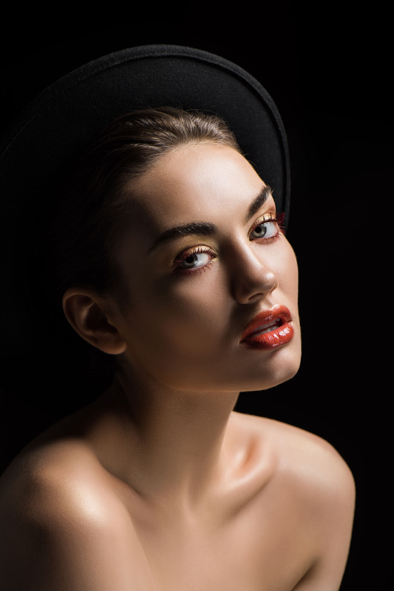 attractive woman posing in felt hat, isolated on black